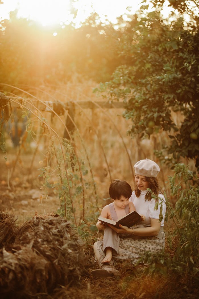 A serene moment captured of a mother and child reading together in a lush garden at sunset in Hatay, Türkiye.